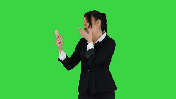 Business Woman Look Into Smart Phone Preening and Dancing on a Green Screen, Chroma Key