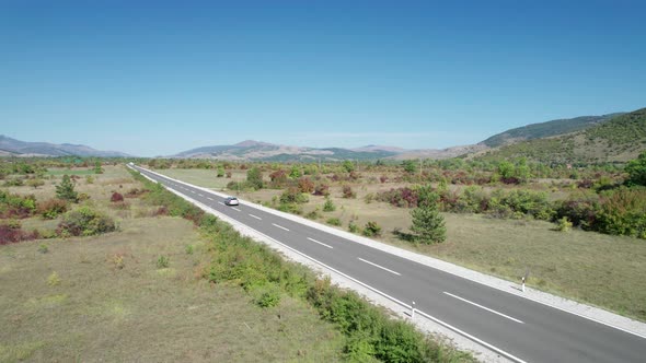 Empty Asphalt Road on the Plateau Between Green Fields Highland Way Aerial View