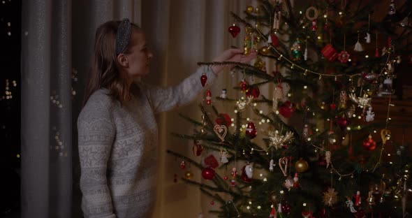 Woman Decorating Christmas Tree at Home