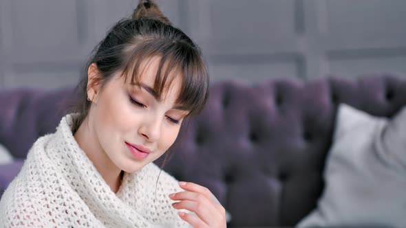 Closeup Portrait of Shy Romantic Woman Enjoying Wrapped in Warm Knitted Plaid in Living Room