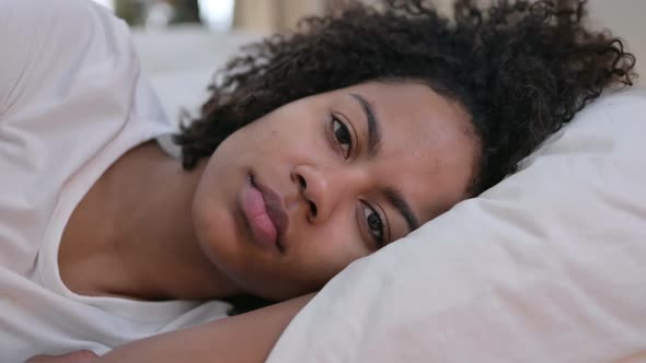 Close Up of African Woman Looking at Camera in Bed