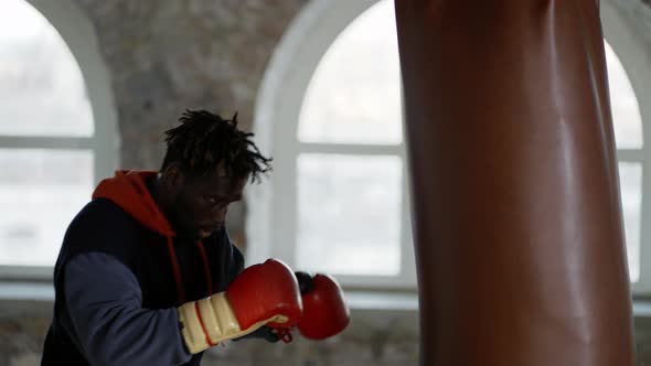 Male Boxer Training at Boxing Studio in Gloves Punching Pear