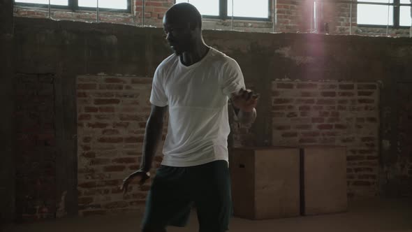 Black man having fun, doing dancing moves indoors