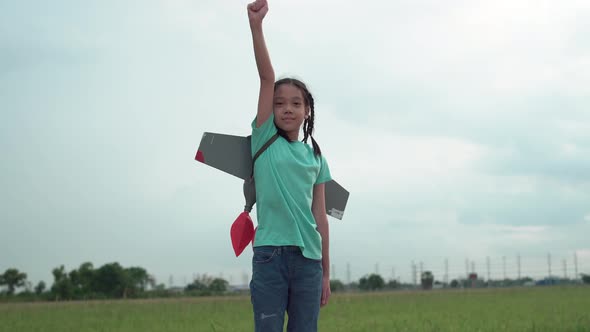 Child girl playing outdoor with toy rocket, Kid flying to sky with rocket jetpact like a superheroes