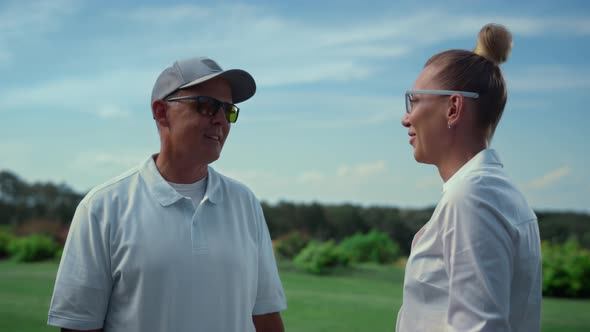 Two Golf Players Discuss Golfing Game at Fairway