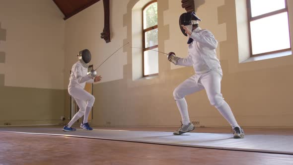 Fencer athletes during a fencing training in a gym