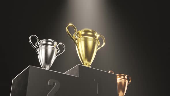 Golden, silver and bronze metallic trophy cups on a podium in the spotlight 4KHD