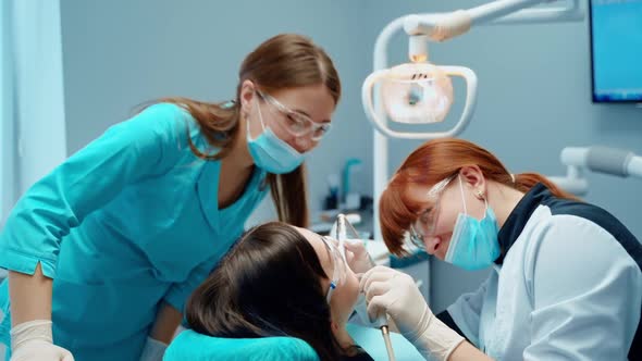 Patient in dental office. Dentist treats patient teeth in modern dental clinic