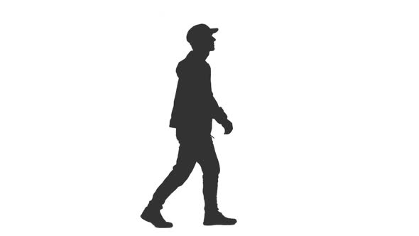 Silhouette of Man Walking in Jacket and Cap