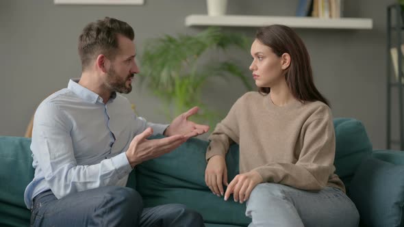Serious Man Talking to Woman While Sitting on Sofa