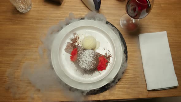 Waiter Serving Dish Lid with Smoke in Restaurant Table