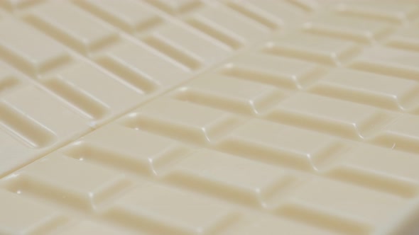 Shiny white milk chocolate blocks in the row slow tilt 4K 2160p 30fps UltraHD video - Tilting over s