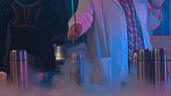 A Scientist Holding a Rose in the Thermos with Liquid Nitrogen alt