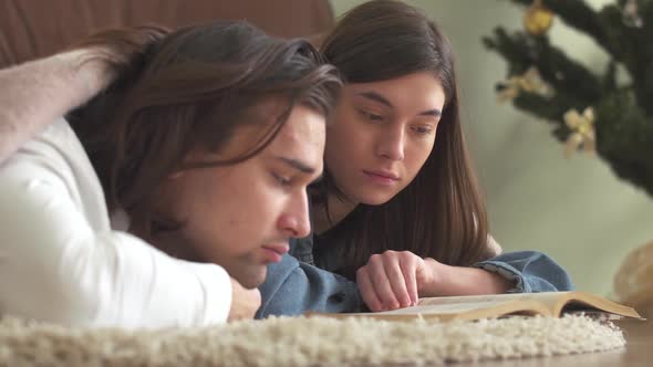 Young Attractive Couple in Love Lying on the Carpet in the Bedroom Covered