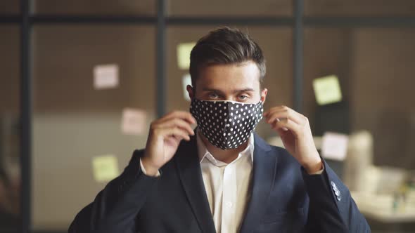 Business Meeting, Young Man in Suit Stands in Conference Room, Man Removes a Cloth Mask, Protect