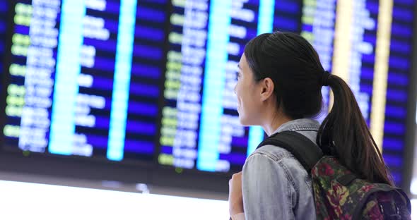 Woman checking the flight number in the airport