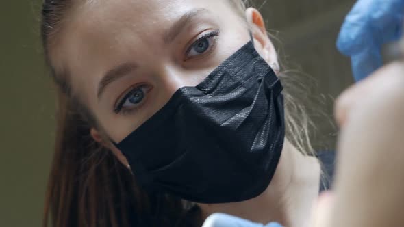 Young Female Dentist Curing Tooth Cavity