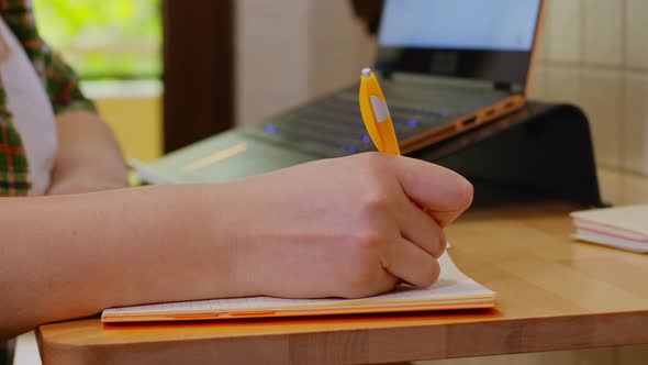 Woman Taking Notes While Working From Home