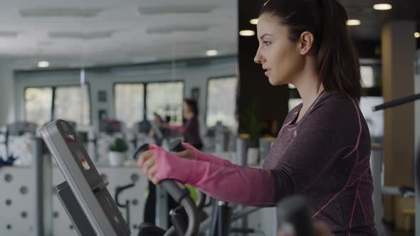 Handheld view of young woman exercising in the gym.  Shot with RED helium camera in 8K