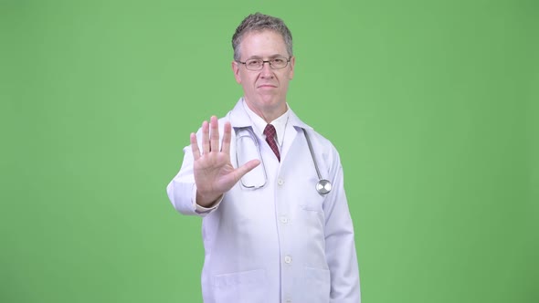 Portrait of Serious Mature Man Doctor with Stop Hand Gesture