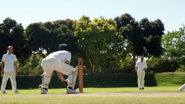 Fielder throwing ball to wicket keeper during cricket match