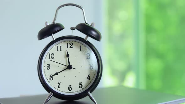 Time on vintage black alarm clock running