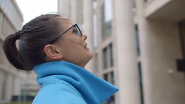 Desperate Young Woman in Blue Coat Crying Outdoors Office Building