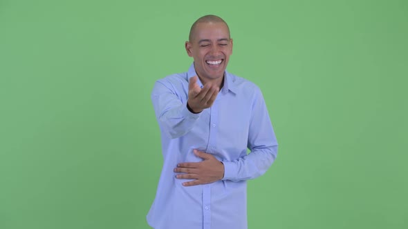Happy Bald Multi Ethnic Businessman Laughing and Pointing at Camera
