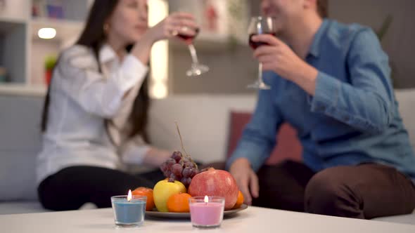 Couple having fun, drinking alcohol and eating fruit.