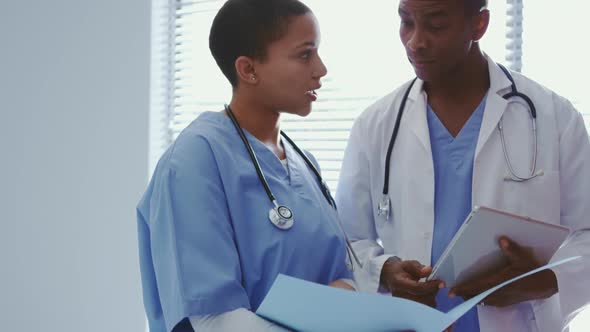 Front view of African African doctors discussing over medical file in hospital 