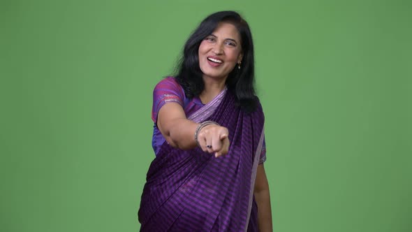 Mature Happy Beautiful Indian Woman Pointing at Camera While Wearing Sari Traditional Clothes