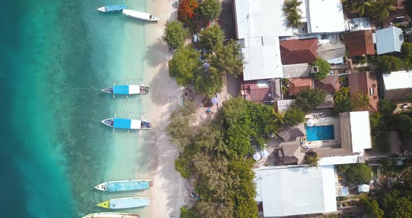 Tropical islands in Indonesia, traditional boats moored on beach, aerial