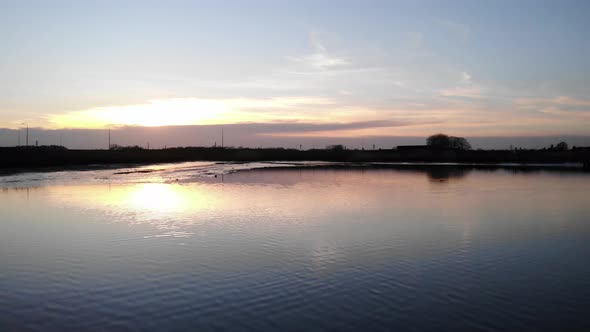 Reflections On Calm Lake At Crezeepolder Near Village Of Ridderkerk In The Netherlands During Sunris