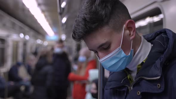 Brunette Young Male in Medical Mask in Metro Car