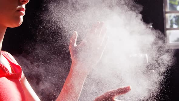 Woman dusting his hands with chalk powder