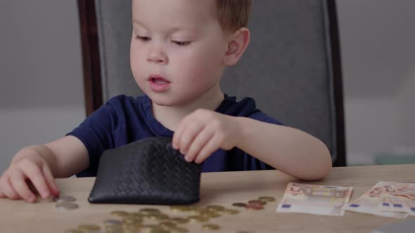 Baby Boy Kid Putting Euro Money Coins Into Black Purse Wallet Savings Education