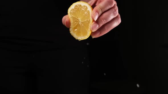 Tracking shot of lemon juice squeeze on plate with food, slow motion.