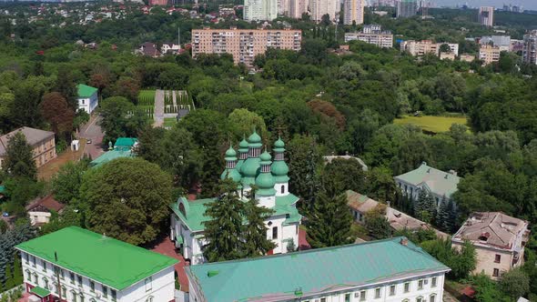 Nice top view of the church. Green domes among the trees. Monastery in the forest.