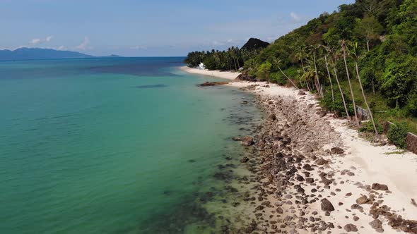 Green Jungle and Stony Beach Near Sea. Tropical Rainforest and Rocks Near Calm Blue Sea on White