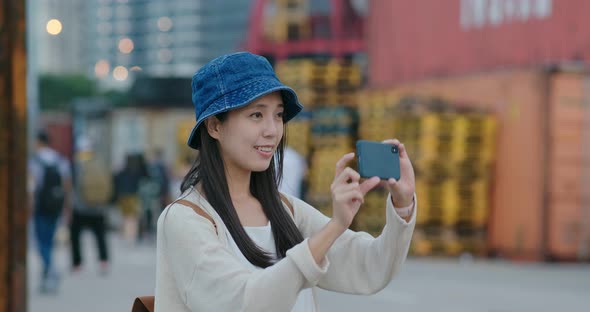 Woman take photo on cellphone in city