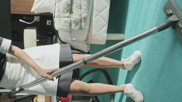 Housekeeper Doing Hoovering in Hotel Room