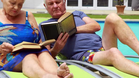 Senior couple reading books on lounge chair