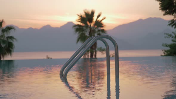 A closeup of an open swimming pool railing against the evening scenery