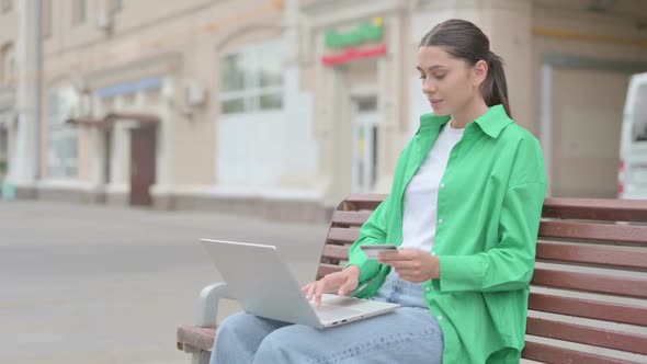 Hispanic Woman Happy for Online Shopping on Laptop Outdoor