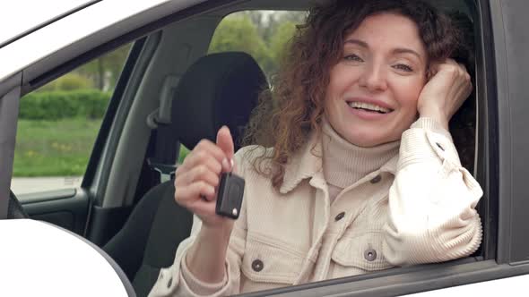 Successful Beautiful Happy Woman in the New Car with Keys