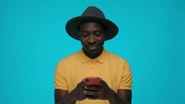 Happy African Man Using Smartphone Over Blue Background