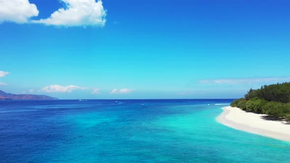 Natural flying tourism shot of a white sand paradise beach and turquoise sea background