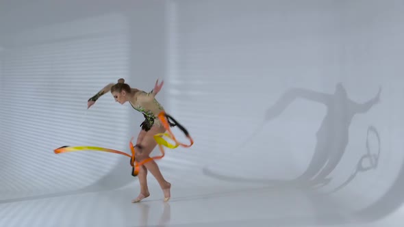 Rhythmic Gymnast Gracefully Dancing with a Ribbon in His Hands. White Background