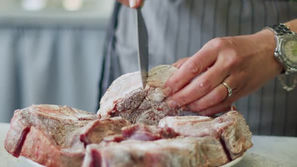 Woman doing incisions on beef rolled in flour