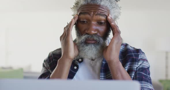 Stressed man massaging his temples at home